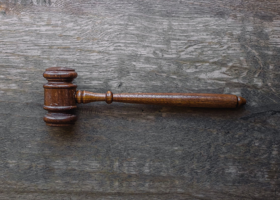 a photo of a wooden gavel on a gray wooden surface